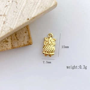 Macro detail of a 15mm golden owl charm pendant with precise measurements and 0.3g weight