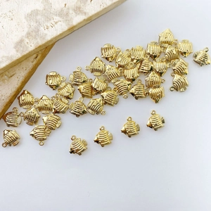 Detail of gold-plated tropical fish charms with textured stripes for DIY jewelry making