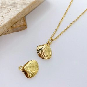 Macro detail of gold shell pendant with radial texture on elegant stone background