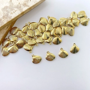 Macro shot of gold-plated shell charms with radiant texture for DIY jewelry making