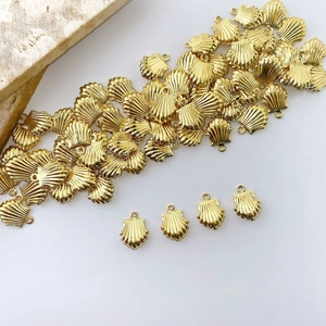 Detailed view of gold-plated scallop shell pendants for DIY jewelry making and crafts