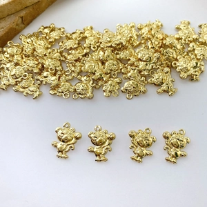 Detailed view of mini golden bear charms for DIY jewelry with shiny metallic finish