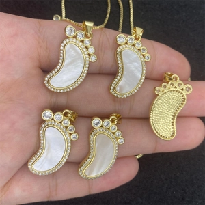 Detail of foot-shaped shell pendant with golden finish and sparkling rhinestones