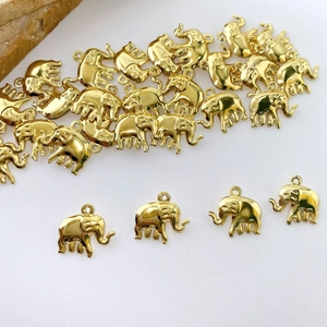 Macro shot of gold-plated elephant charms for DIY jewelry making on white background