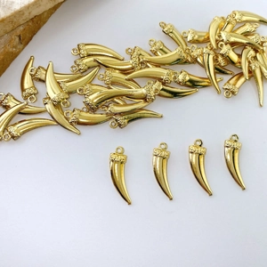 Detailed close-up of bright gold plated claw-shaped pendant for DIY jewelry design