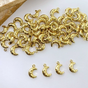 Detail of gold moon charms with star engravings and top rings for DIY jewelry making