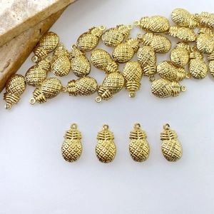 Detailed macro view of a golden pineapple charm with textured finish for DIY jewelry making