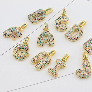 Detailed close-up of gold-plated alphabet pendants set with multi-colored cubic zirconia