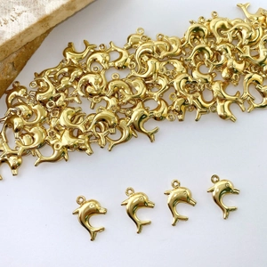 Macro shot of gold-plated dolphin charms with metallic luster for DIY jewelry making