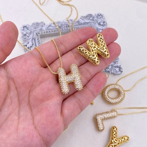 Macro shot of gold-plated balloon letter pendants with sparkling cubic zirconia inlay