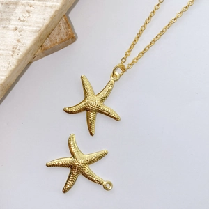 Detailed macro view of a golden starfish pendant with realistic textured metal finish