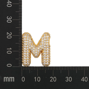 Detailed view of zircon-encrusted letter M pendant measuring 23mm on a scale