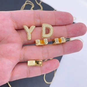 Close-up of gold-plated letter D and Y pendants with pavé-set sparkling zircons