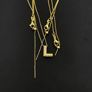 Close-up of golden letter L pendant with zircon inlay and adjustable lobster clasp chain