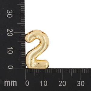 Détail du pendentif doré chiffre 2 montrant les dimensions sur une règle