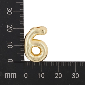 Vue macro d'un pendentif ballon chiffre 6 doré sur une règle montrant les dimensions