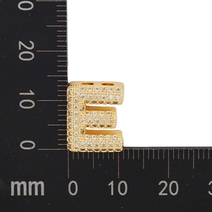 Macro scale shot showing 11mm gold letter E pendant with cubic zirconia micro-pave setting