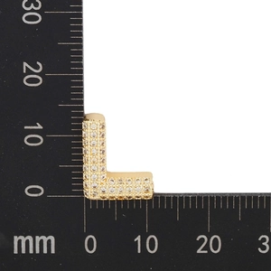 Macro shot of gold pave-set cubic zirconia letter L pendant measuring 13mm by 9mm