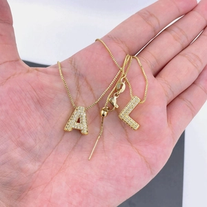 Adjustable golden box chain necklace featuring sparkling zircon-paved A and L pendants