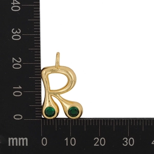 Macro detail of gold letter R pendant with green zircon stones showing 20mm size scale