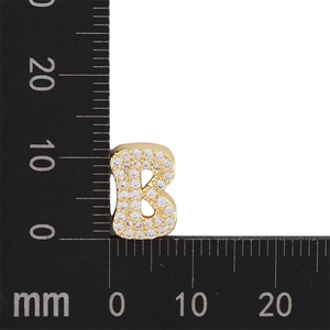 Nahaufnahme von Gold-Buchstabe-B-Anhänger mit Zirkonia neben einem Messlineal