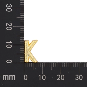 Macro view of 12mm gold-plated letter K charm showing detailed texture and dimensions