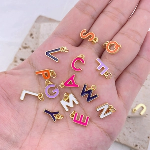 Gros plan de breloques lettres colorées en émail pour colliers et bracelets DIY