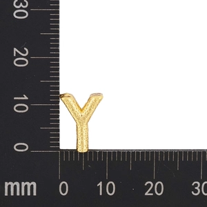 Detail showing letter Y pendant with dotted texture on a measuring scale ruler