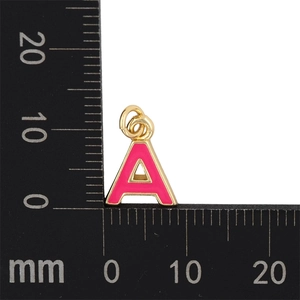 Détail du pendentif lettre A en émail rose avec mesure précise sur une règle