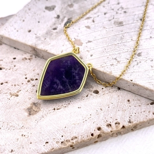 Collar vintage de oro con un colgante geométrico de amatista púrpura sobre piedra