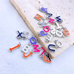 Close-up of colorful enamel alphabet letter charms for DIY jewelry and necklaces