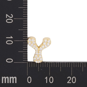 Makroaufnahme von goldenem Y-Anhänger mit Zirkonia auf einer Messskala für Schmuck