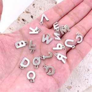 Macro shot of 26 English letter metal charms for DIY jewelry making in polished silver finish