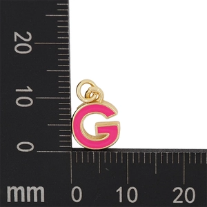Détail macro du pendentif lettre G en émail rose avec cadre doré pour bijoux DIY