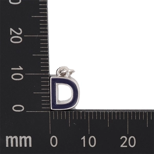 Macro shot of blue enamel letter D pendant with measurements in millimeters