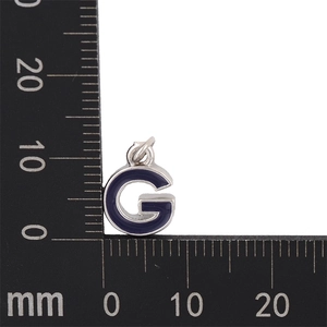 Macro shot of 10mm blue enamel letter G pendant on a scale ruler for size measurement