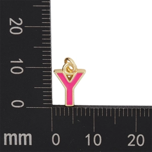 Vue macro d'un pendentif lettre Y en émail doré et rose de 13mm avec une règle
