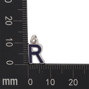 Macro shot of purple enamel letter R pendant with metal ruler showing 13mm height