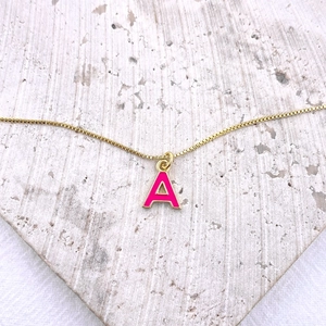 Collier chaîne box dorée avec pendentif lettre A en émail rose fuchsia sur fond pierre