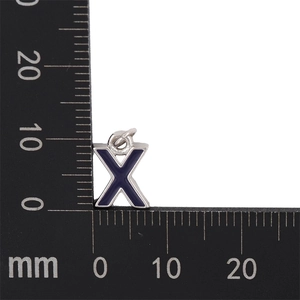 Close-up of a blue enamel letter X charm for DIY jewelry making next to a ruler