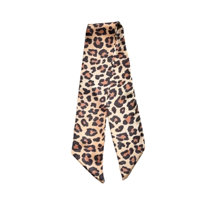 Leopard print silk scarf bracelet with pointed edges on a clean white background