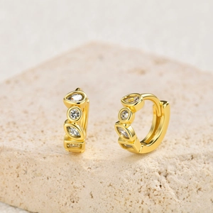Detail of 18K gold-plated huggie earrings with multi-shape zircon inlays on stone base