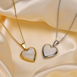 Detailed view of gold and silver locket necklaces with mother of pearl on silk