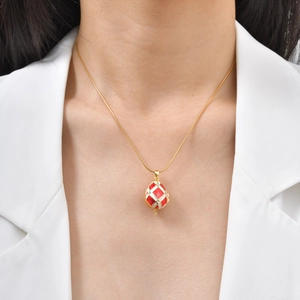 Collier avec pendentif œuf à croix dorée en émail rouge et blanc et cristaux