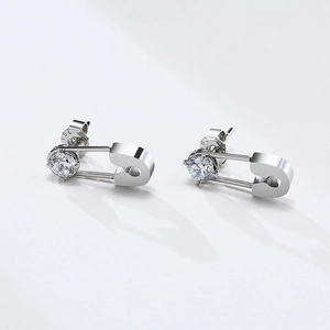 Macro view of silver safety pin earrings with a sparkling round-cut cubic zirconia stone