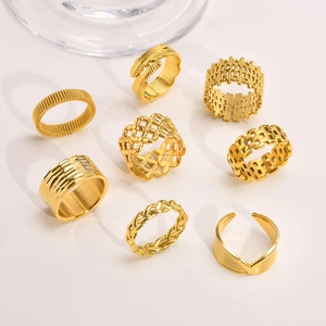 Detail van acht gouden roestvrijstalen ringen met gaas- en veerpatronen set