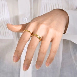 Set of two minimalist polished gold stainless steel rings worn on fingers