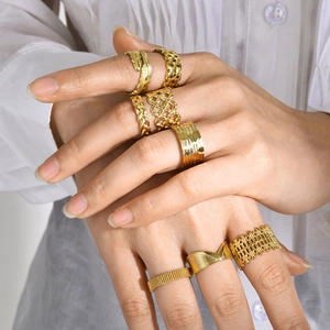 Detailopname van gouden ringen met veer- en vlechtontwerpen op de hand van een model