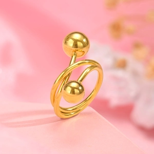 Detalle macro de un anillo espiral bañado en oro con dos esferas pulidas en los extremos