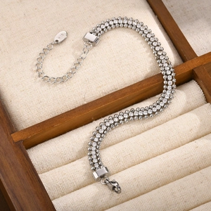 Détail d'un bracelet trois rangs en zircon blanc et acier avec étiquette en or 18K